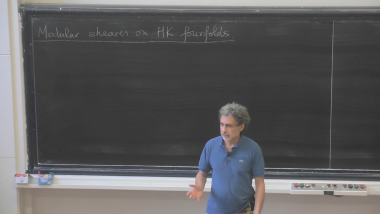 Hyperkähler fourfolds of Kummer type: modular sheaves and projective models