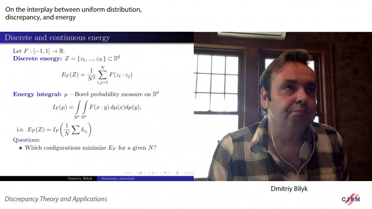 On the interplay between uniform distribution, discrepancy, and energy minimization